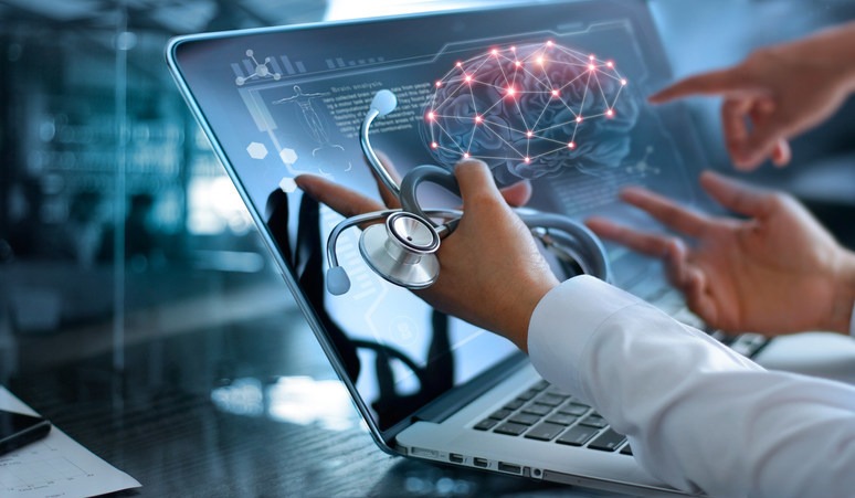 Clinicians reviewing an AI brain analysis on a laptop